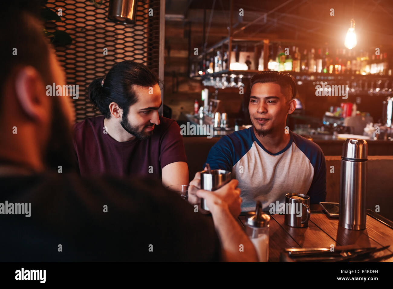 Gruppe von gemischten Rennen junge Männer Trinken von Tee in der Lounge Bar. Mitte - östliche Freunde Spaß im Cafe sharing Getränke Stockfoto