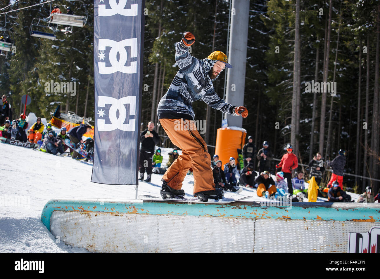 BUKOVEL, UKRAINE-24. März, 2018: Snowboard jib Contest auf Schienen im Snow park. Snowboarder Athleten in Schleifen auf Rohr mit Snow Board deck konkurrieren. Cool Stockfoto