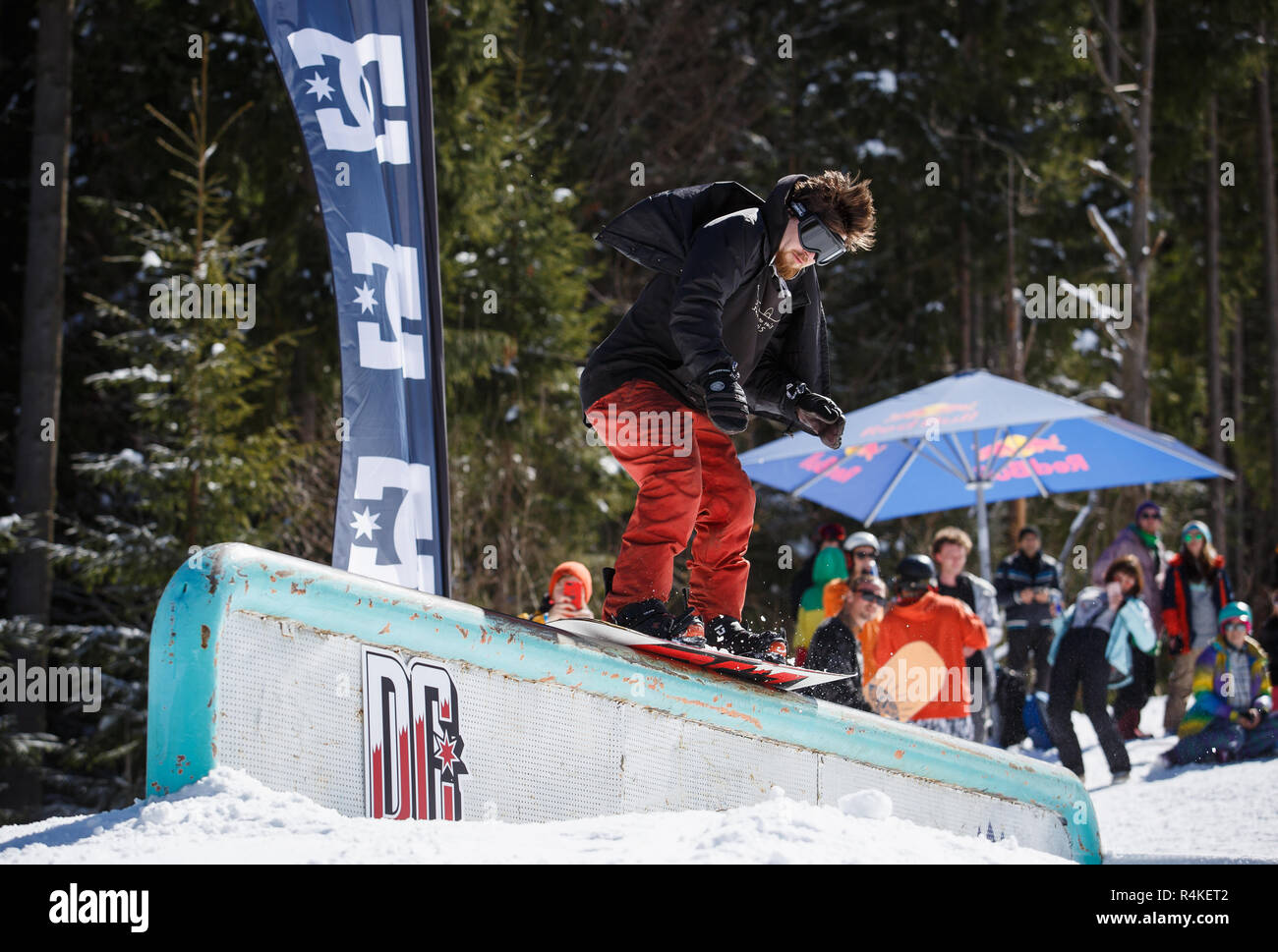 BUKOVEL, UKRAINE-24. März, 2018: Snowboard jib Contest auf Schienen im Snow park. Snowboarder Athleten in Schleifen auf Rohr mit Snow Board deck konkurrieren. Cool Stockfoto