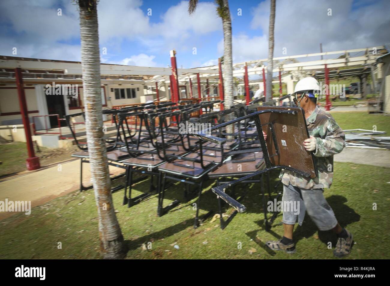 Ein Saipan öffentlichen Arbeitnehmer nimmt Schreibtische von Innen von Saipan Volkshochschule nach Super Typhoon Yutu, November 2, 2018. Super Typhoon Yutu war der stärkste Wirbelsturm über Saipan und Tinian in der Nördlichen Marianen. Stockfoto