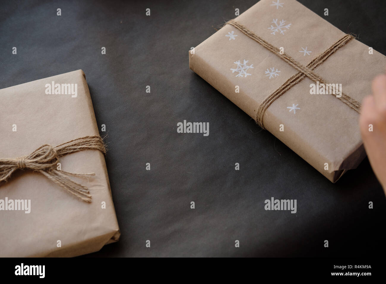 Frau Zeichnung auf Papier Schneeflocken Paket Weihnachten, Geschenk auf schwarzem Hintergrund. Weibliche Hände malen auf Geschenke für Winterurlaub. Weihnachten, Ne Stockfoto