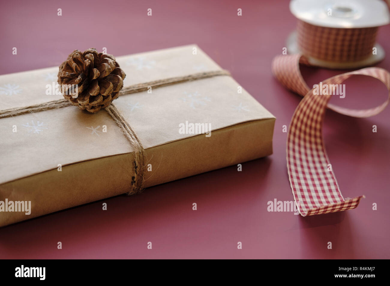 Weihnachten Geschenk Box auf Burgund, Marsala Farbe Hintergrund. Weihnachtsgeschenk mit handgefertigten Schmuck. Close Up. Platz kopieren Stockfoto