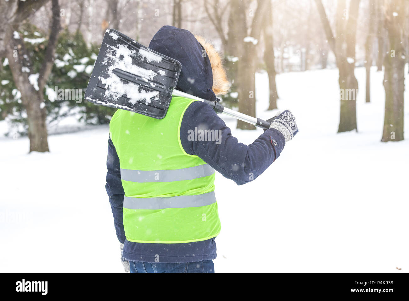 Ansicht der Rückseite des Mann hält Schaufel über seine Schulter und Vorbereitung der Schneeschaufeln. Stockfoto