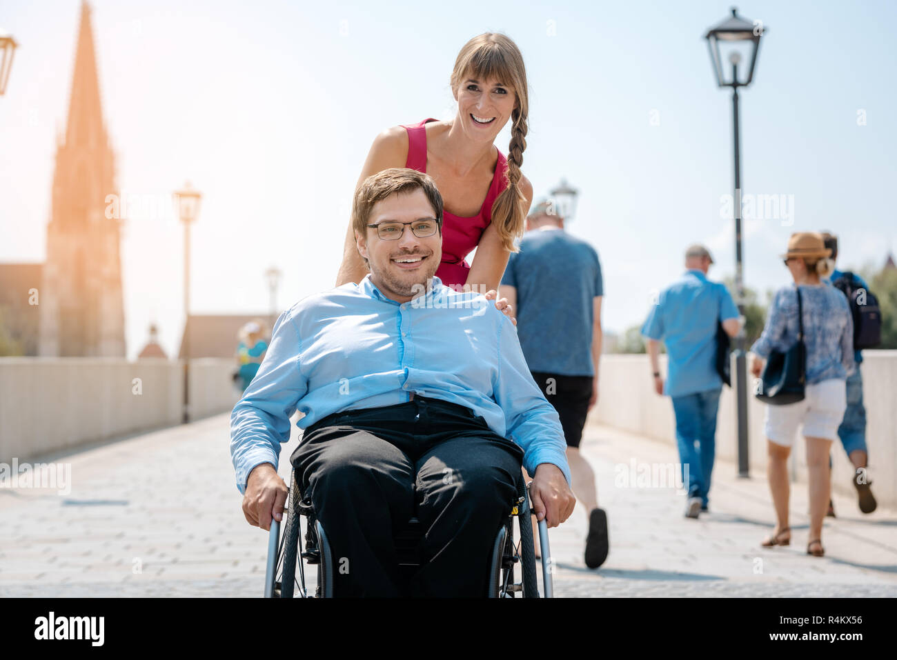 Frau und ihr Freund im Rollstuhl in einen Spaziergang durch die Stadt Stockfoto