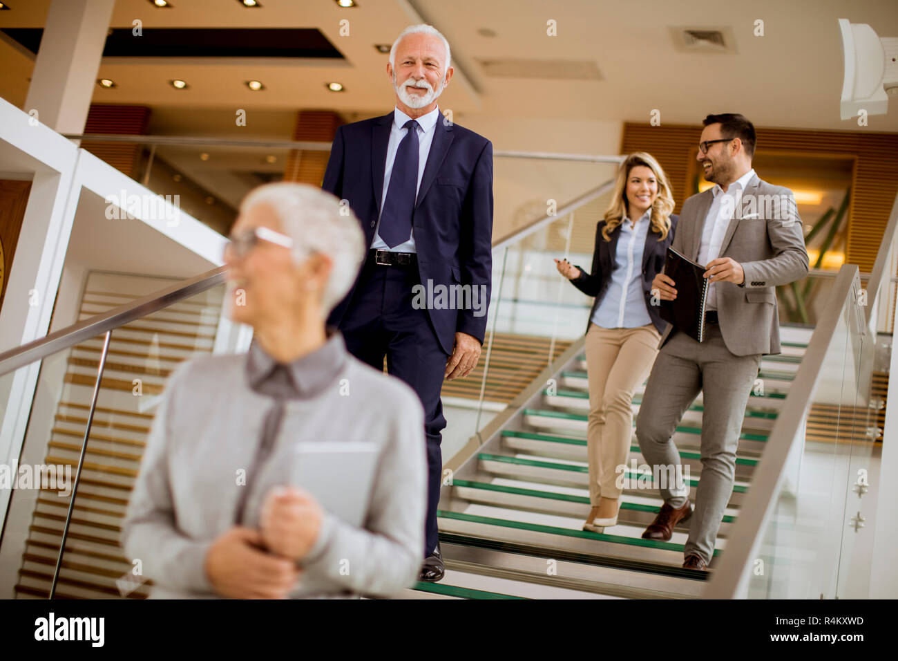 Gruppe der Unternehmer und Unternehmerinnen zu Fuß und unter Treppen in einem Bürogebäude Stockfoto