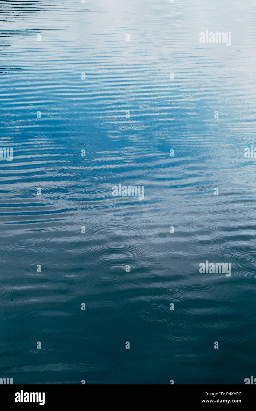 Blue Water See Oberfläche mit Regentropfen Kreise vertikale Hintergrund Stockfoto