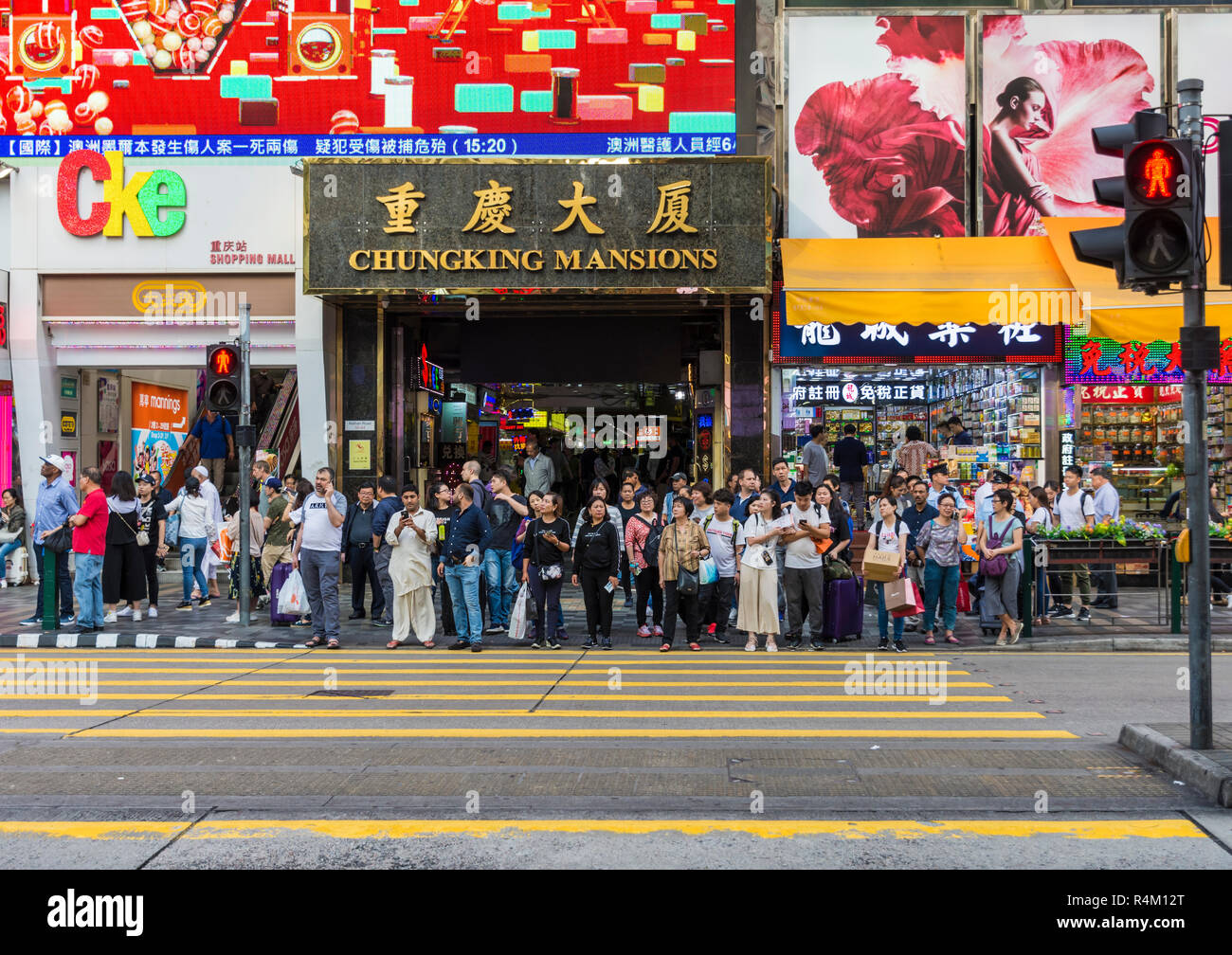 Menschen, die darauf warten beim Zebrastreifen außerhalb Chungking Mansions, Nathan Road, Tsim Sha Tsui, Kowloon, Hong Kong Stockfoto