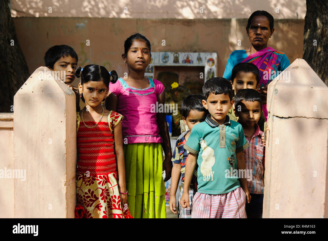 Gruppe der indischen armen Kinder mit Mutter an Kamera schaut. 11. Februar 2018 Puttaparthi, Indien Stockfoto