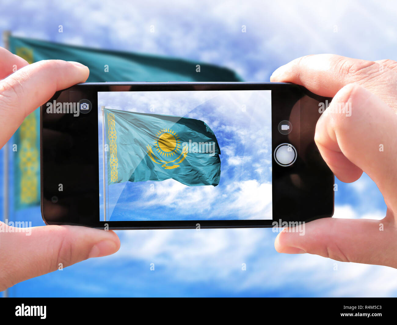Das Konzept des Tourismus und Reisen. Die Hände der Männer machen ein Foto vom Telefon. Schießen aus dem Smartphone Flagge Kasachstan Fahnenmast wieder Stockfoto