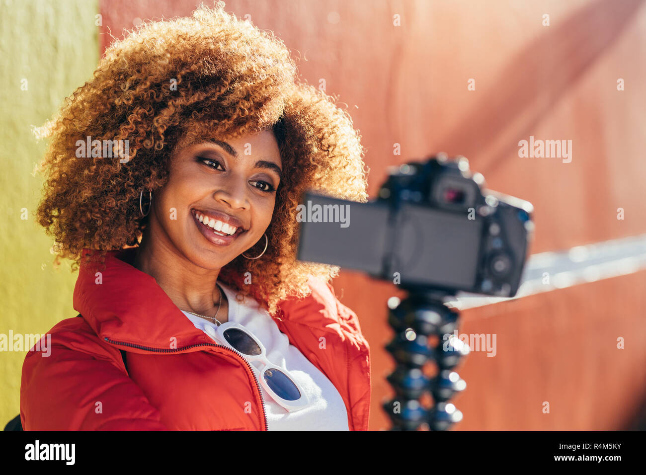 Fröhliche afro-amerikanische Frau die Aufnahme Inhalt für Ihre Reise Blog im Freien. Porträt einer Frau, ein selfie im Freien mit einer DSLR-Kamera. Stockfoto