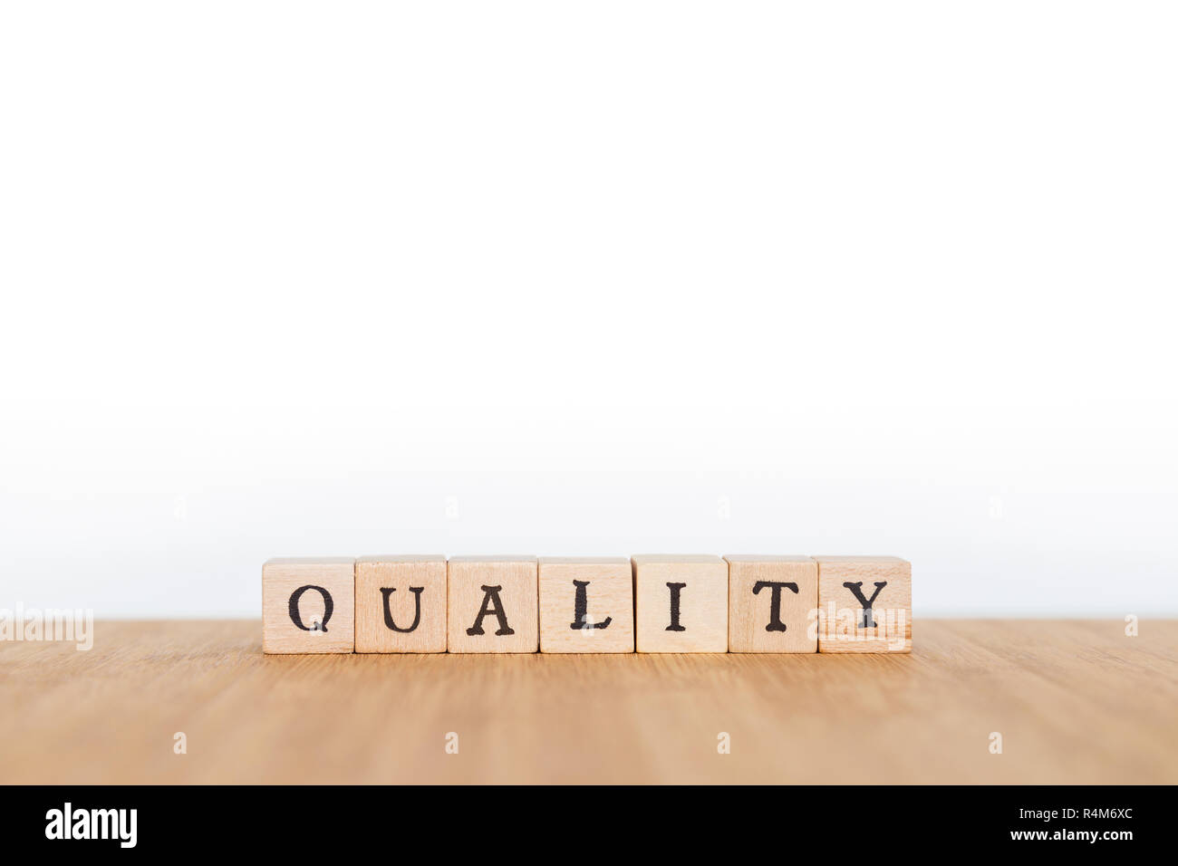 Konzentrieren Sie sich auf das Wort "Qualität" aus Holz Würfel mit Buchstaben auf einem Holztisch. Geringe Tiefenschärfe. Kopieren Sie Platz. Stockfoto