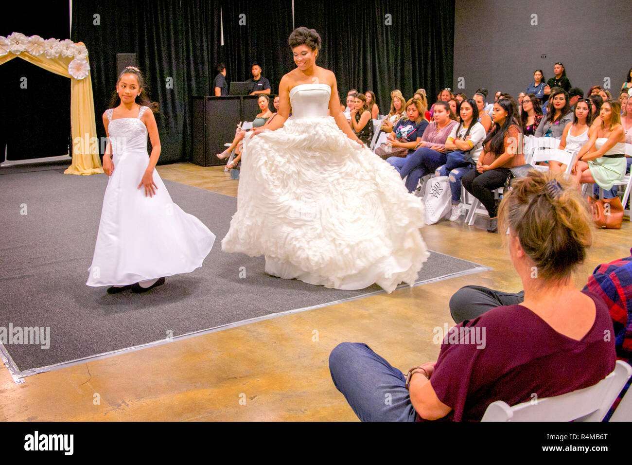 Ein Hispanic Mutter und Tochter Modell Braut- und der Braut Mädchen Kleider an einem bridal Fair Fashion Show in Costa Mesa, CA. Stockfoto