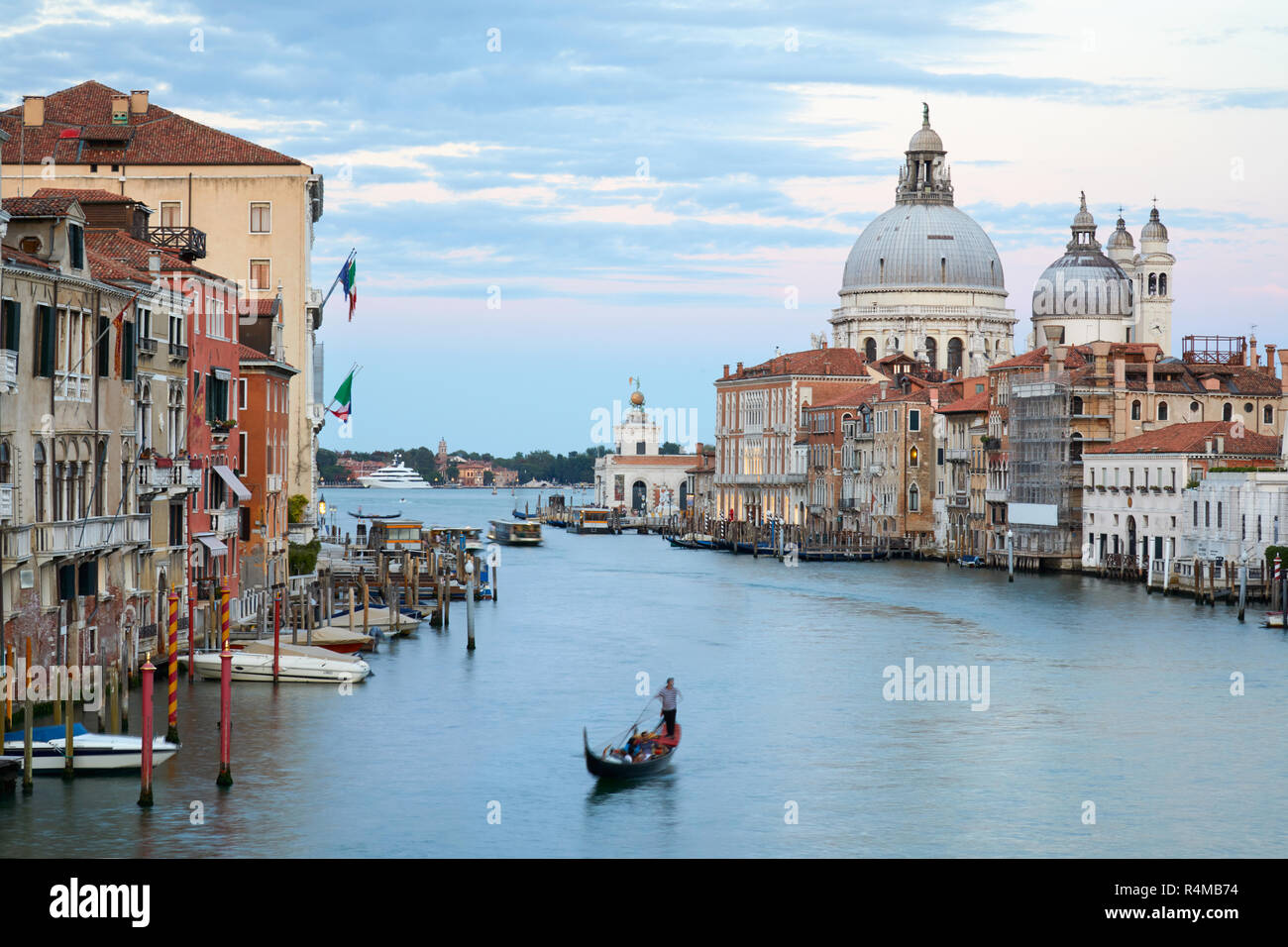 Grand Canal in Venedig mit Gondelfahrt und der Hl. Maria von Gesundheit Basilika in der Dämmerung in Italien Stockfoto