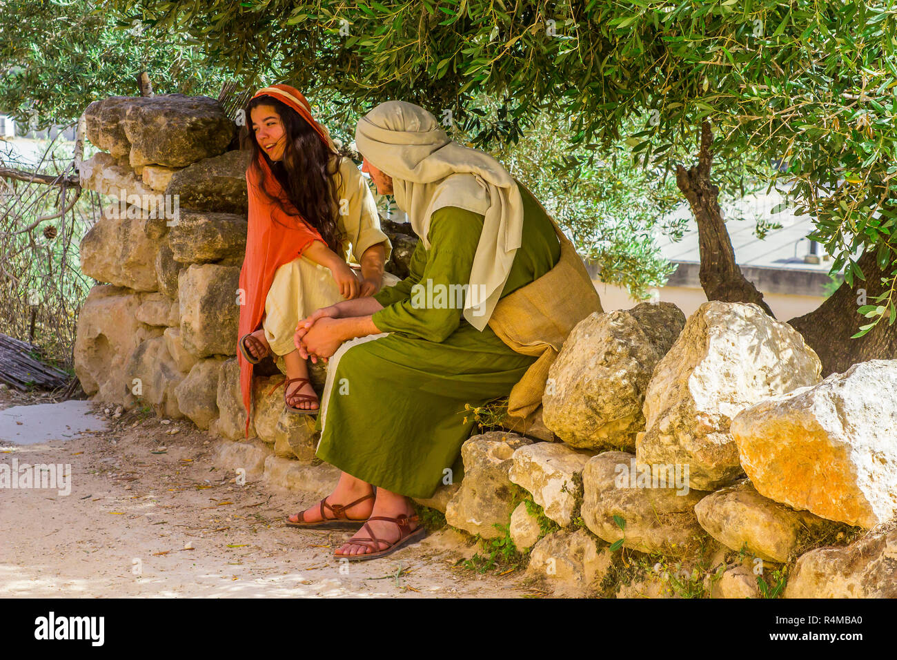 Ein junger Mann und eine Frau in Kostümen im Freilichtmuseum von Nazareth Village Israel. Diese Website bietet einen Blick auf das alte Israel Stockfoto