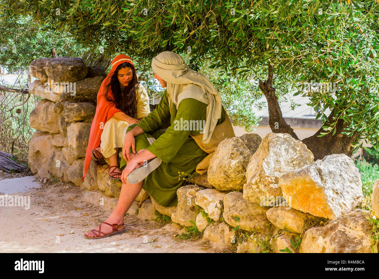 Ein junger Männer und Frauen in Kostümen im Freilichtmuseum von Nazareth Village Israel. Diese Website bietet einen Blick auf das Leben im alten Israel Stockfoto