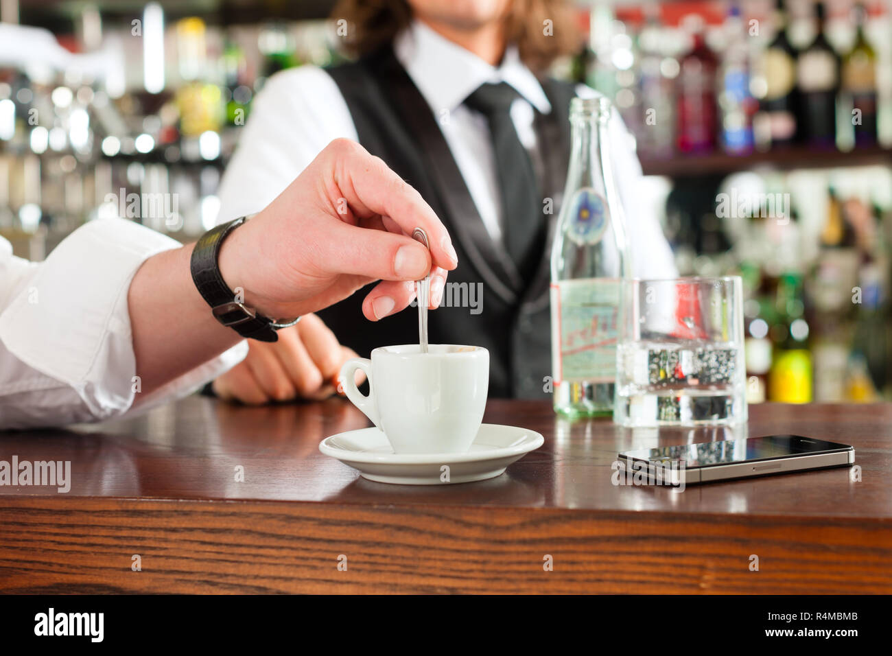 Barista mit Client in seinem Cafe oder Coffeeshop Stockfoto