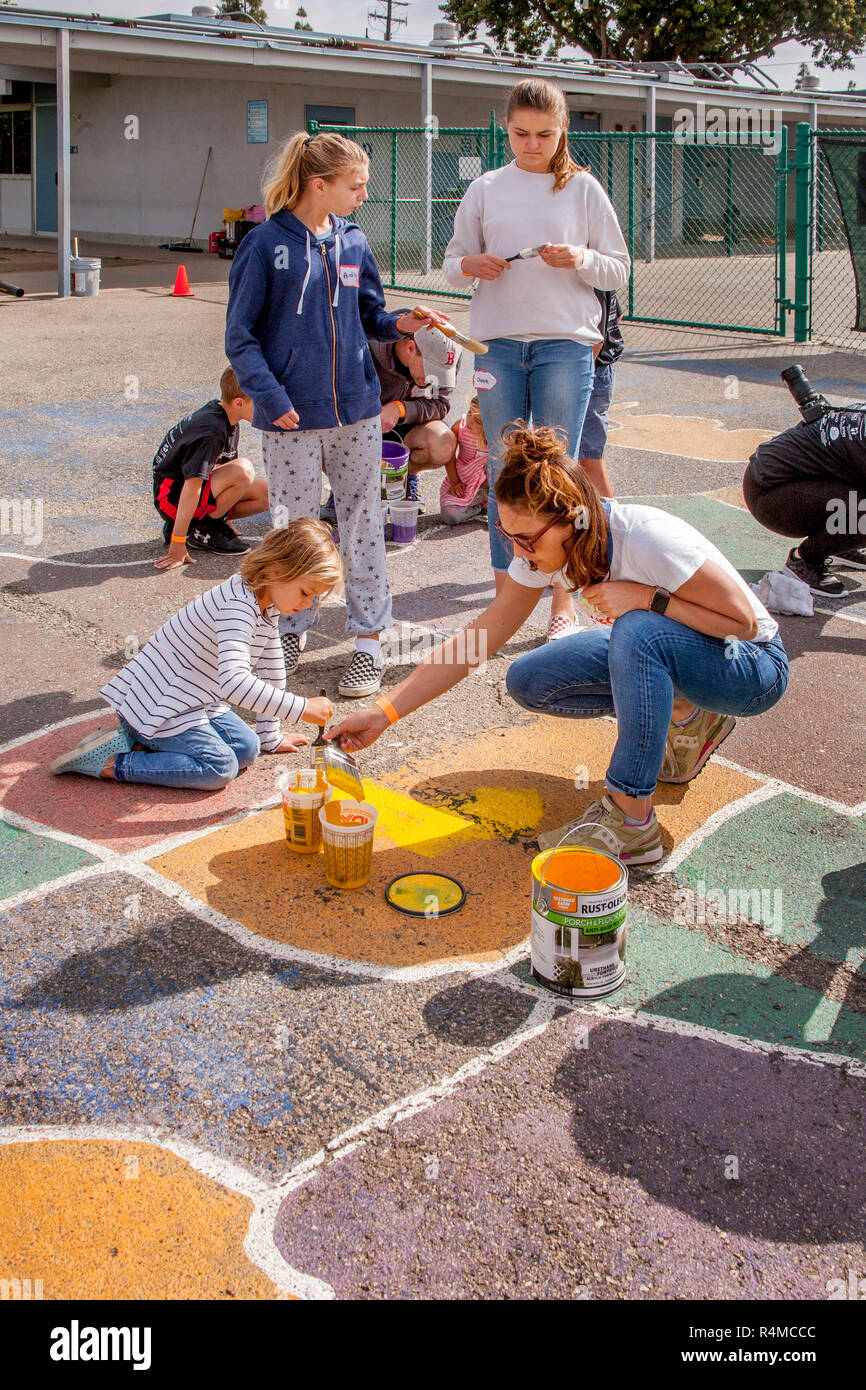 Schüler, Studenten, Eltern und Lehrkörper freiwillige Arbeit bei Malerarbeiten und Wiederherstellen einer Karte der USA in einen Schulhof in Costa Mesa, CA. Stockfoto