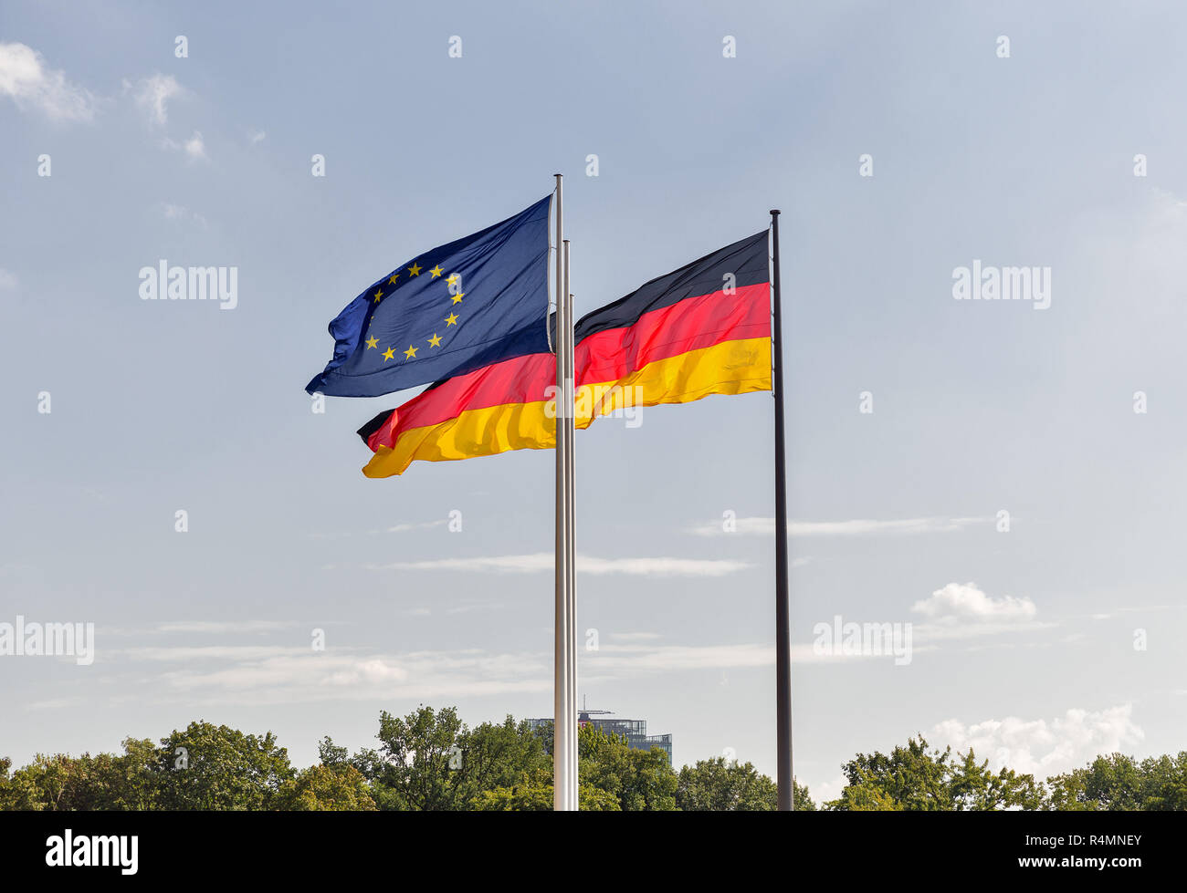 Deutsche und Europäische Union Flaggen Streaming auf fahnenmasten gegen Himmel Hintergrund in Berlin, Deutschland. Stockfoto