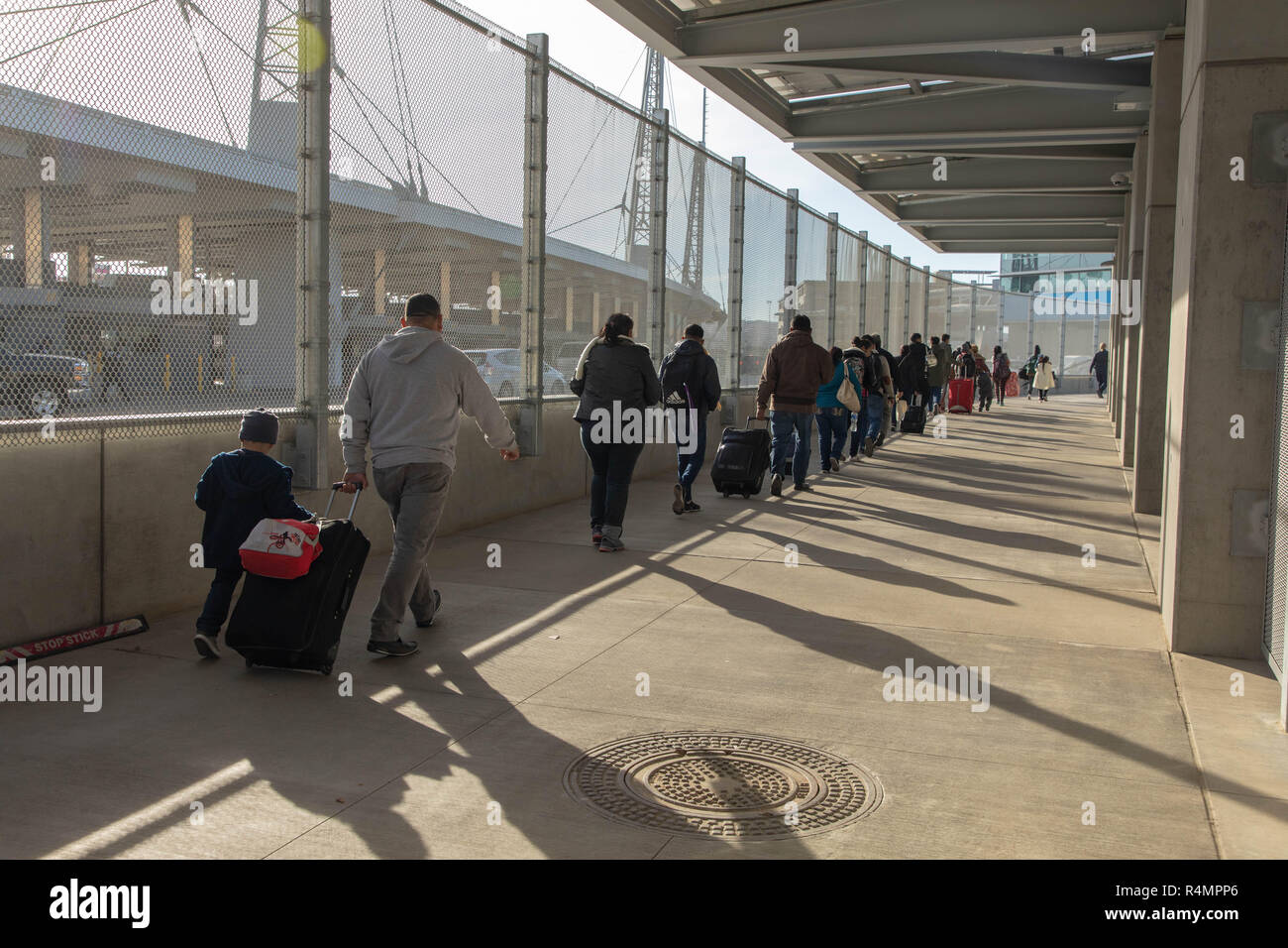 Asylbewerber aus der Migrant Caravan sind für die Verarbeitung durch einen Zoll- und Border Patrol-Agenten auf den San Ysidro 23. November, 2018 Kreuzung in San Ysidro, Kalifornien begleitet. Der Grenzübergang in San Ysidro ist die verkehrsreichste land Überfahrt in den Vereinigten Staaten mit 70.000 Fahrzeuge und 20.000 in nördlicher Richtung Norden Fußgänger jeden Tag überschreiten. Stockfoto