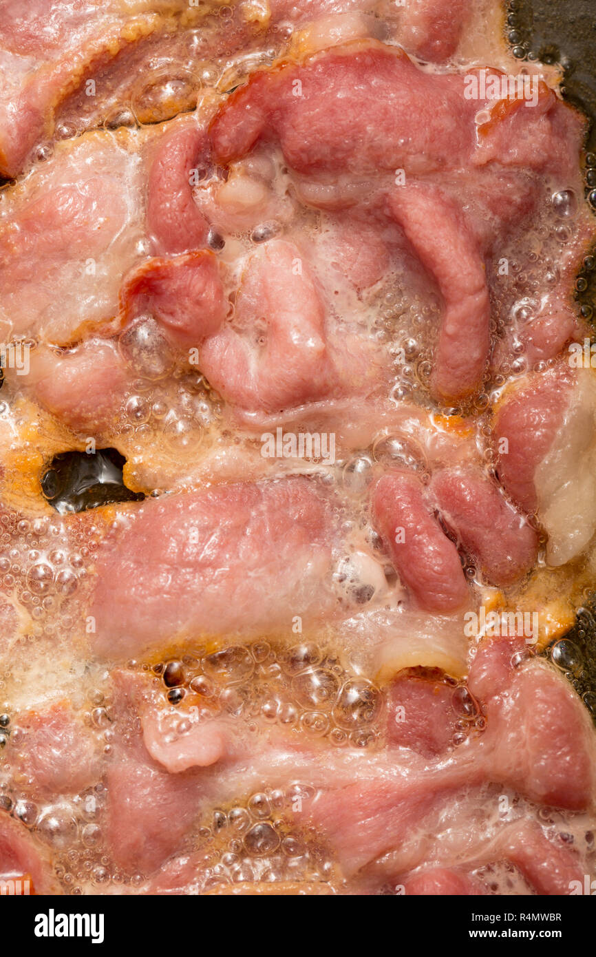 Geräucherter Schinken Speckschnitten, die in der EU produziert, gekauft von einem britischen Supermarkt Speck gebraten, ein Sandwich zu machen. England UK GB Stockfoto