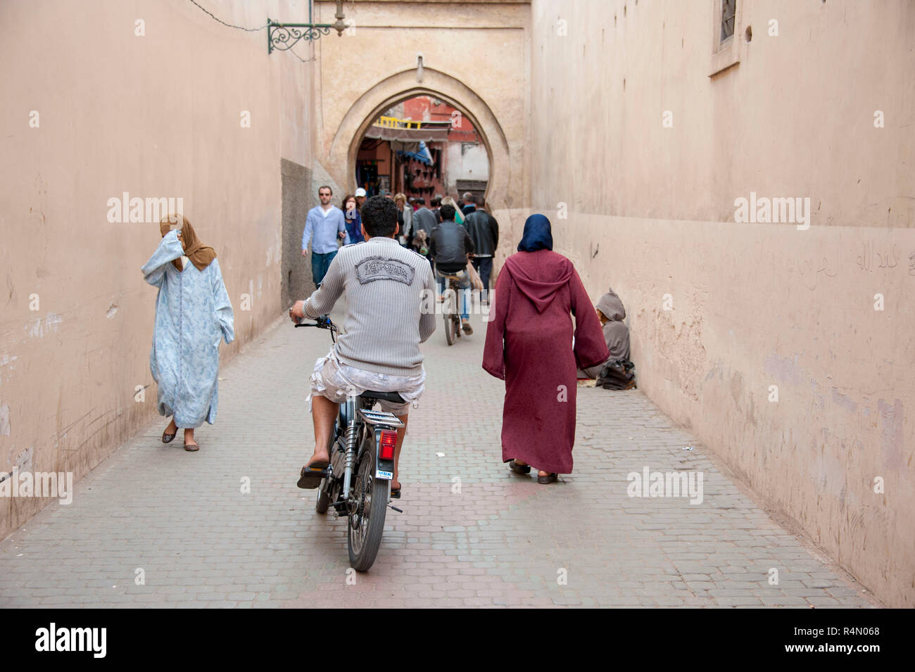 18-04-11. Marrakesch, Marokko. Straßenszene in der Medina, mit einem Motorroller weben zwischen Passagieren. Foto © Simon Grosset/Q-Fotografie Stockfoto