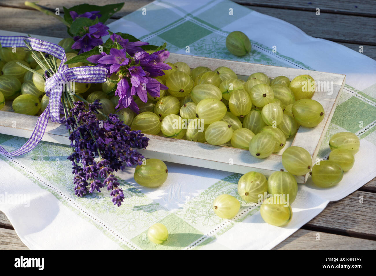 Sommer Ambiente mit stachelbeeren auf Holz Fach liebevoll mit Blumen und Jam jar eingerichtet Stockfoto