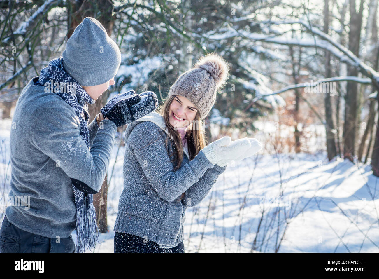Junges Paar in Liebe weht der Schnee im Winter Forest. Paar in Liebe Spaß Stockfoto