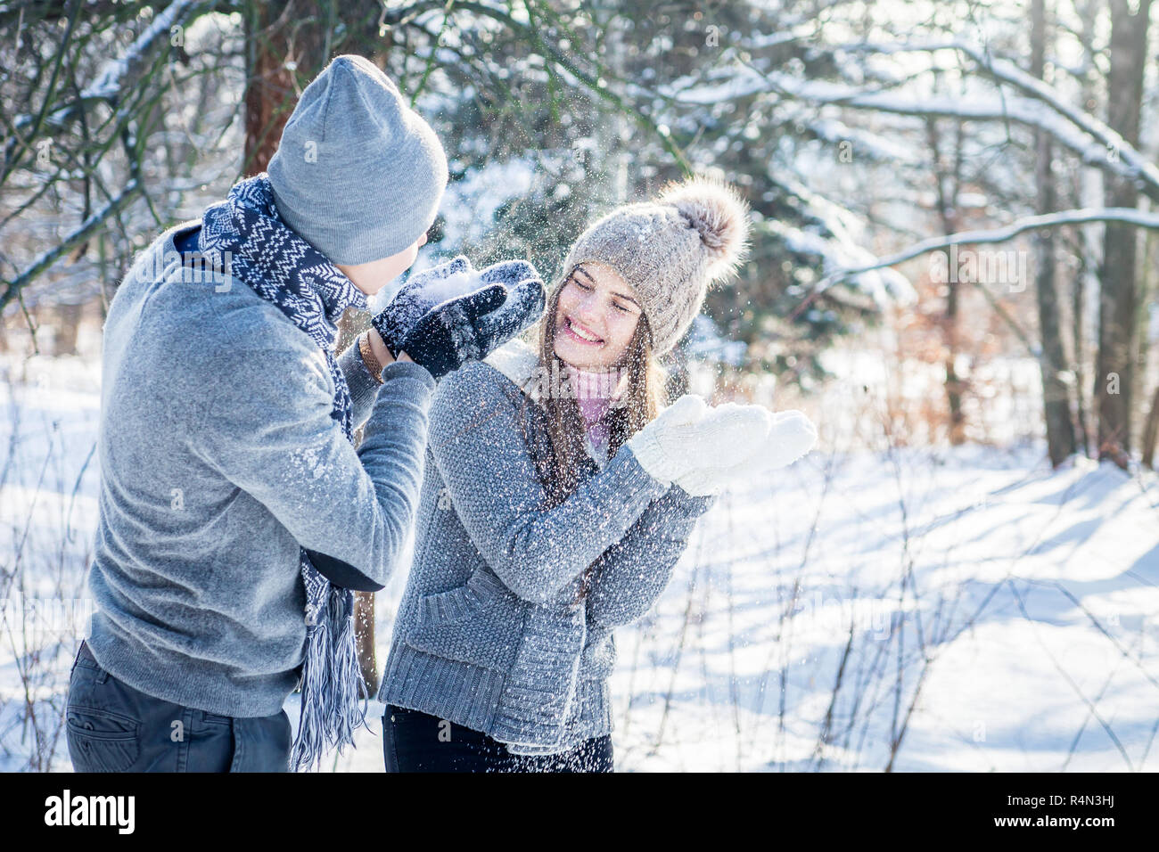 Junges Paar in Liebe weht der Schnee im Winter Forest. Paar in Liebe Spaß Stockfoto