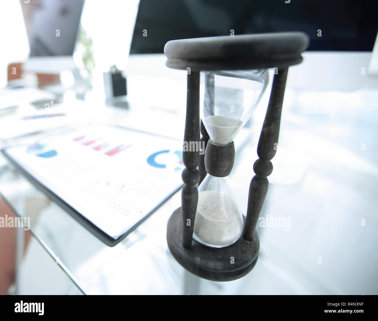 Die Grafik und die Sanduhr auf dem Schreibtisch Stockfoto