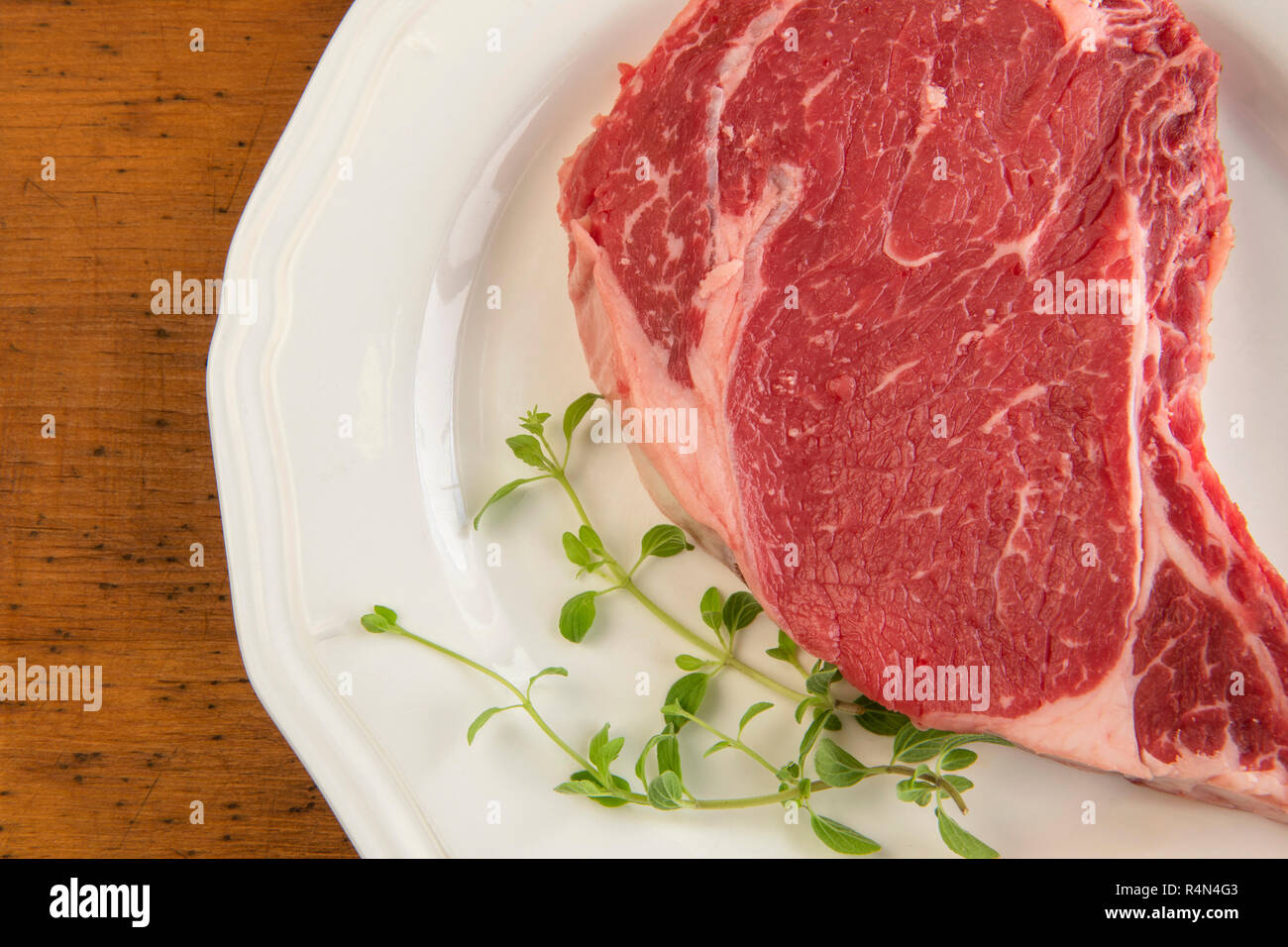 Rohen Steak und Oregano auf Platte Stockfoto