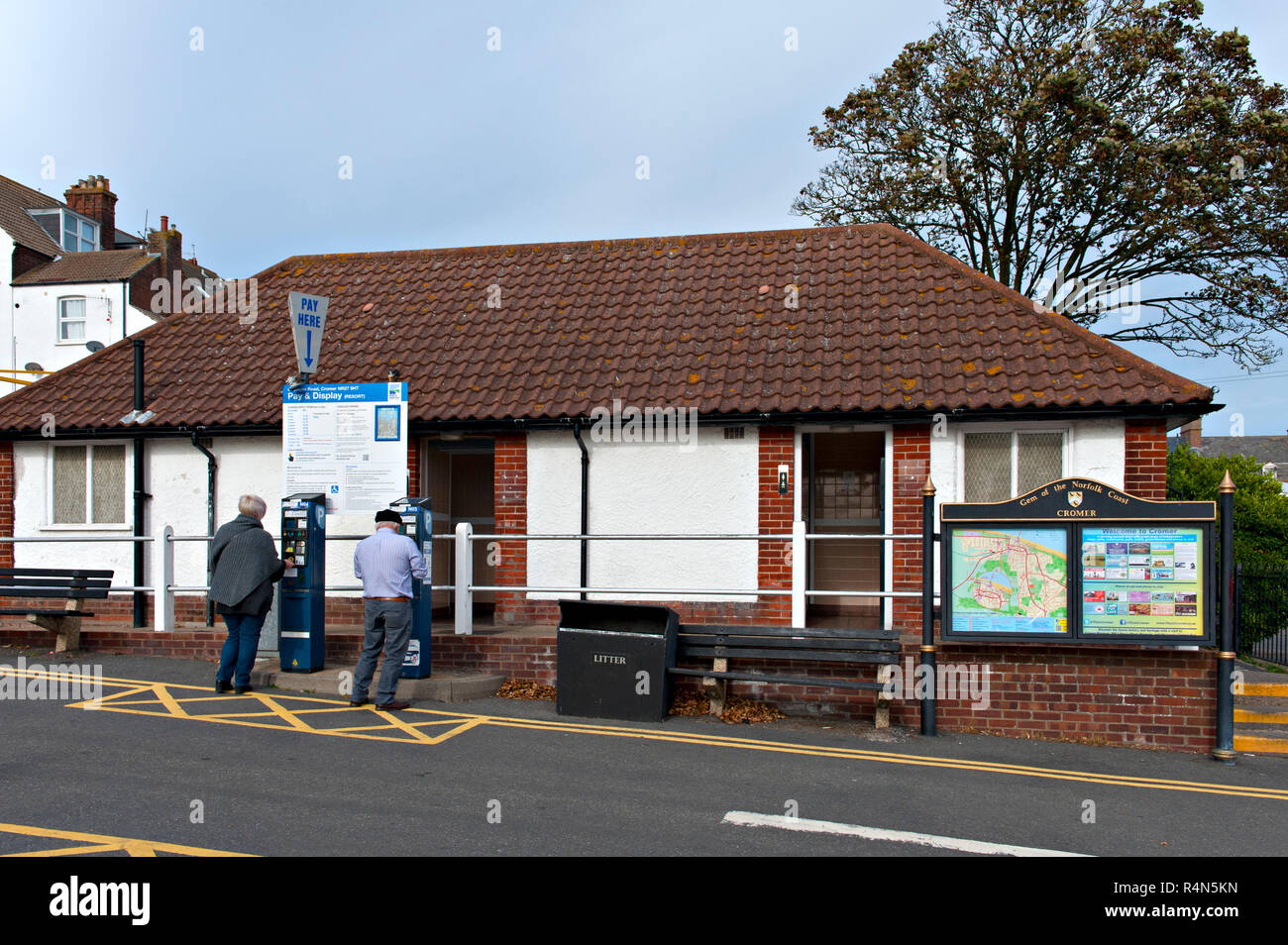 Zwei Personen erhalten Parkscheine an einem öffentlichen Parkplatz in Cromer, Norfolk, Großbritannien Stockfoto