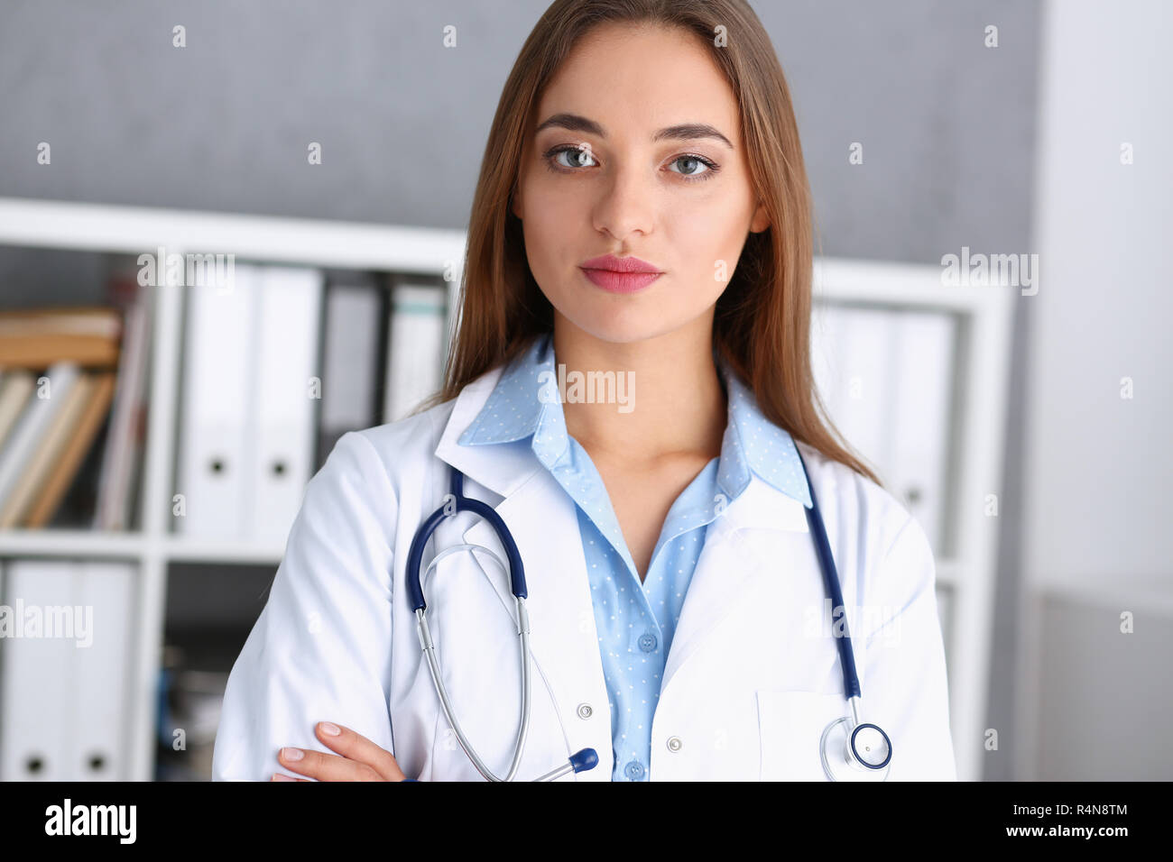 Schöne lächelnd weibliche Arzt stand im Büro Stockfoto