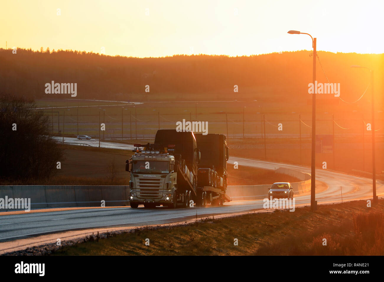 Salo, Finnland - 24. November 2018: Scania Fahrzeug carrier Hols neue Lkw an das warme Licht des Sonnenuntergangs an Umgehungsstraße, im Winter am Nachmittag in Finnland. Stockfoto