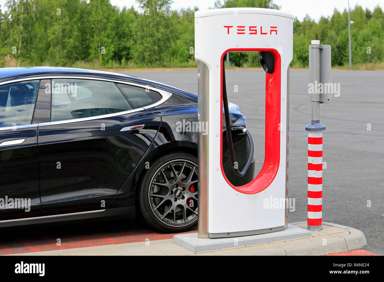 Toijala, Finnland - 17. Juni 2018: Schwarz Tesla Model S voll elektrischen Auto gesteckt Batterie bei Tesla Kompressor station am Tag der Sommer zu berechnen. Stockfoto