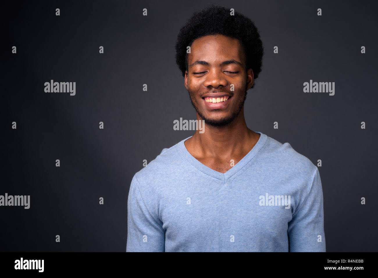 Junge schöne afrikanische Menschen gegen den grauen Hintergrund Stockfoto