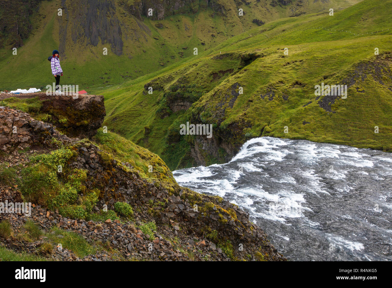 Touristen visitÂ Skogafoss, einem der kultigsten Wasserfälle in Island. Autobahnnähe eigenen (auch als Ring Road bekannt), den Wasserfall Kaskaden 60 Meter und hat Wanderwege, die Besuchern erlauben bis zu Recht auf die unteren und oberen von den Wasserfällen entfernt. Der Wasserfall ist auf der Skoga Fluss, der durch das Hochland von Island reisen, bevor er den Atlantik erreicht. entfernt Stockfoto