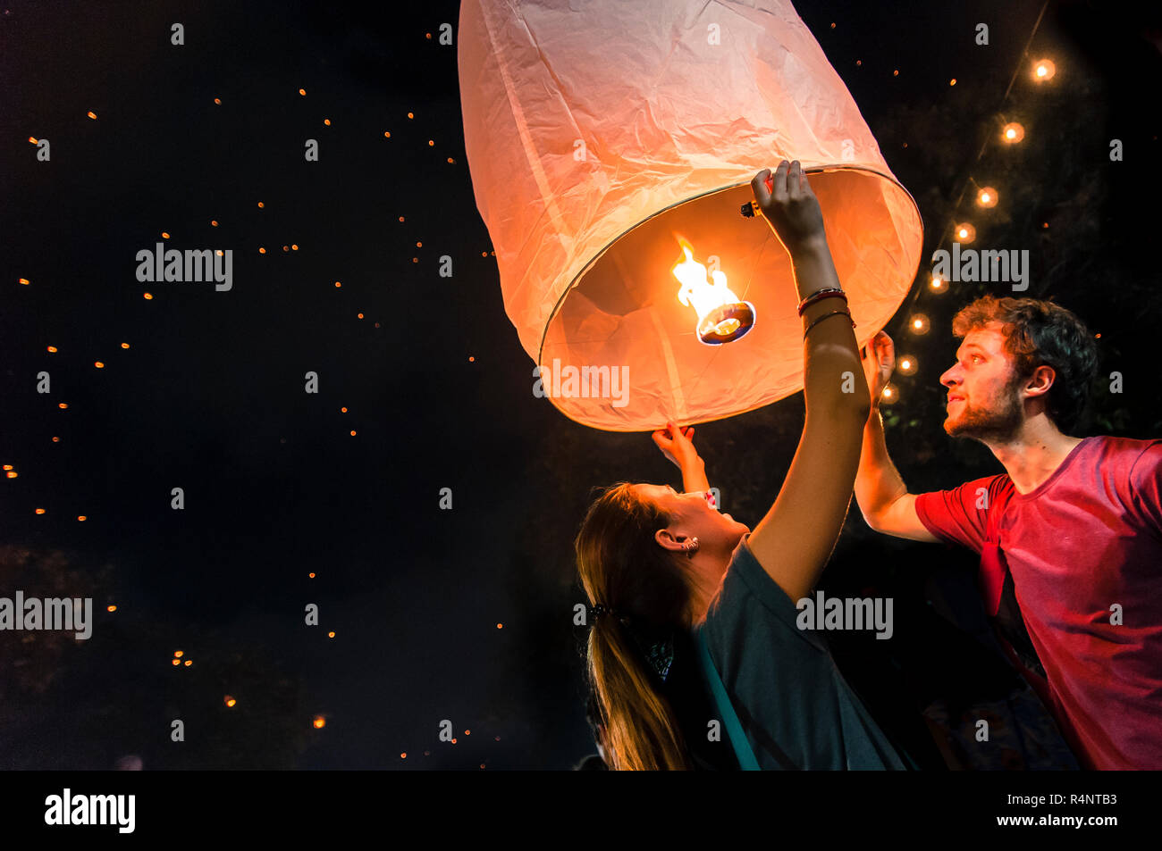 Der Mann und die Frau, die eine neue Laterne während Yi Peng Festival, Chiang Mai, Thailand Stockfoto