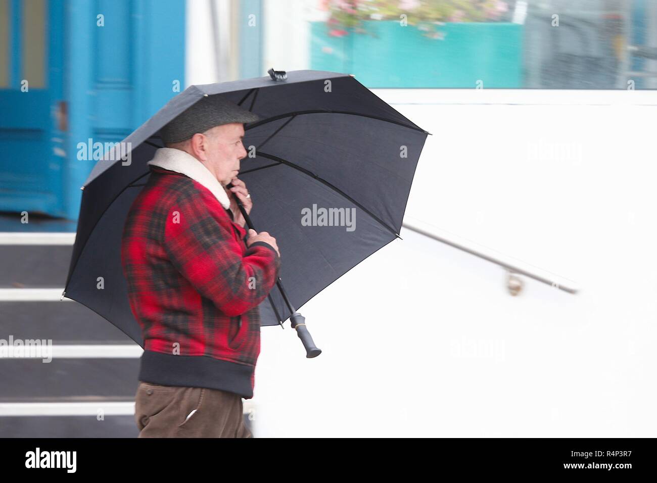 Hastings, East Sussex, UK. 28 Nov, 2018. UK Wetter: Sturm Diana Hits die Stadt mit mit nur wenigen Menschen trotzen die windigen und regnerischen Wetter. Windböen werden voraussichtlich auf 50 mph und anhaltender Regen überschreiten, ist für die nächsten Tage prognostiziert. Dieser Mann hält an zu seinen Regenschirm so fest wie er kann. © Paul Lawrenson 2018, Foto: Paul Lawrenson/Alamy leben Nachrichten Stockfoto