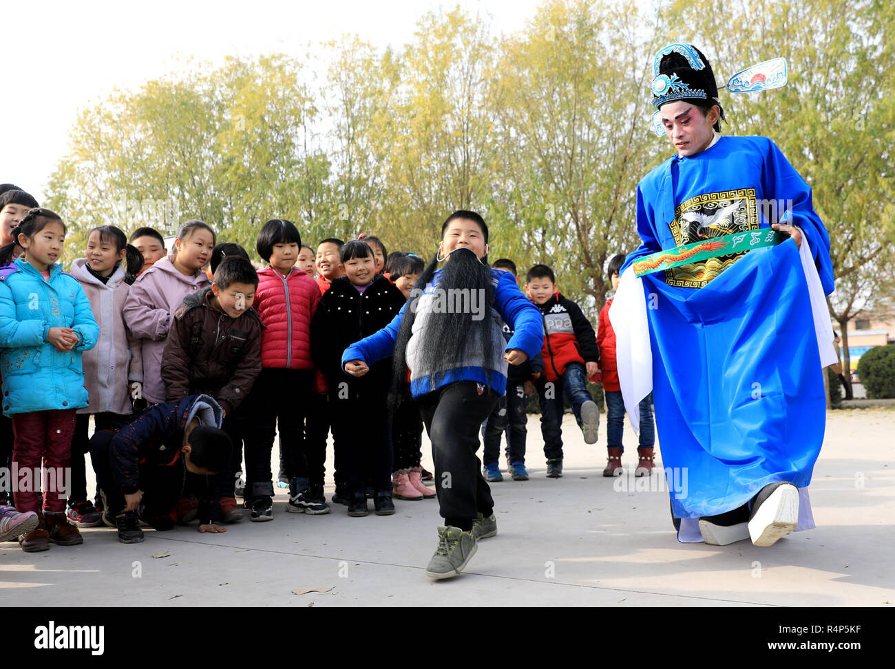 (181128) - SHIJIAZHUANG, November 28, 2018 (Xinhua) - ein Schauspieler von "Kehaiqiang" interagiert mit Schülerinnen an Lijiazhuang Grundschule in Jinzhou Stadt Shijiazhuang, der Hauptstadt von North China Provinz Hebei, Nov. 28, 2018. 'Kehaiqiang', lokalen Drama von Balladen entstanden, als einer der immateriellen Kulturerbes Shijiazhuang in 2013 aufgeführt wurde. Eine Truppe von 'Kehaiqiang' mit Schülern in Campus interagiert, um ihre Interessen in die traditionelle Kunst (Xinhua/Zhao Danhui) (zwx zu heben) Stockfoto