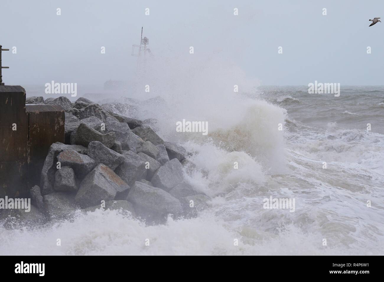 Hastings, East Sussex, UK. 28 Nov, 2018. UK Wetter: Sturm Diana Hits die Stadt mit mit nur wenigen Menschen trotzen die windigen und regnerischen Wetter. Windböen werden voraussichtlich auf 50 mph und anhaltender Regen überschreiten, ist für die nächsten Tage prognostiziert. Der Hafen Arm nimmt ein zerschlagen, als die Flut kommt. Credit: Paul Lawrenson/Alamy leben Nachrichten Stockfoto