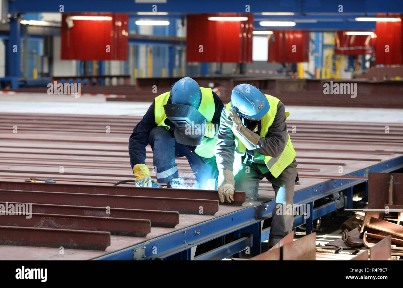 Rostock, Deutschland. 28 Nov, 2018. Nach der feierlichen Inbetriebnahme einer neuen Laser Hybrid panel Linie an der Warnemünde Ort der MV Werften, Ralf Golzer (l) und Jens Wegner Profil einrichten Ein deck. Die Teile werden dann automatisch verschweißt. Die neue Anlage in der 400 Meter langen Halle wird großen Stahlplatten für die Kreuzfahrtschiffe der Globalen Klasse produzieren. Quelle: Bernd Wüstneck/dpa/Alamy leben Nachrichten Stockfoto