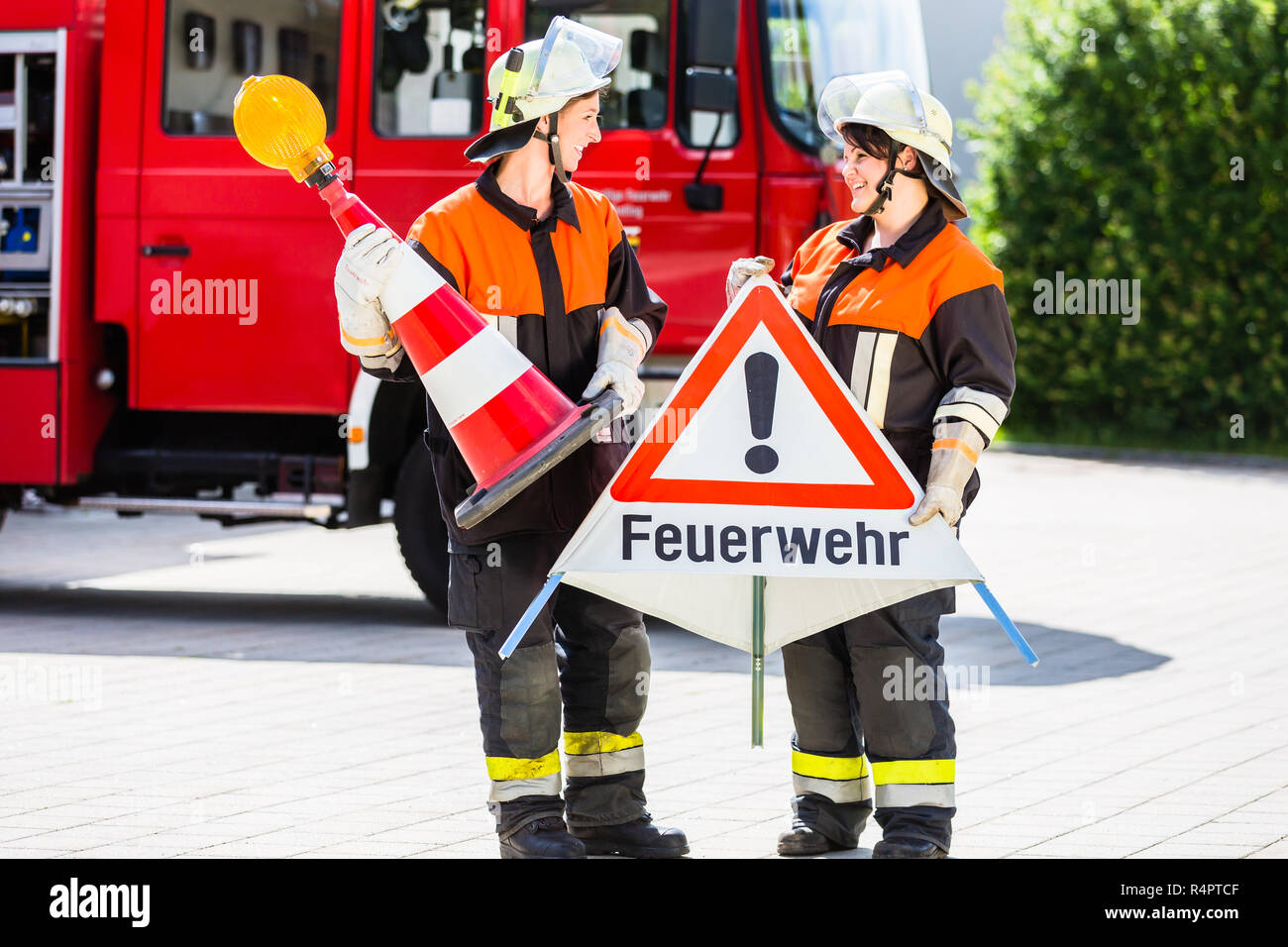 Weibliche Feuerwehrleute einrichten Aufmerksamkeit Zeichen Stockfoto