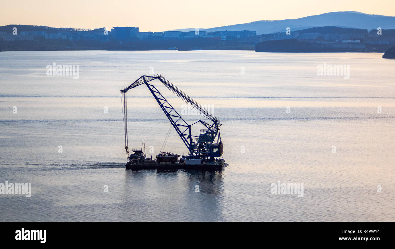 Schwimmkran auf dem Hintergrund der Insel russische Segel durch den Bosporus Osten in der Fernöstlichen Stadt Wladiwostok. Stockfoto