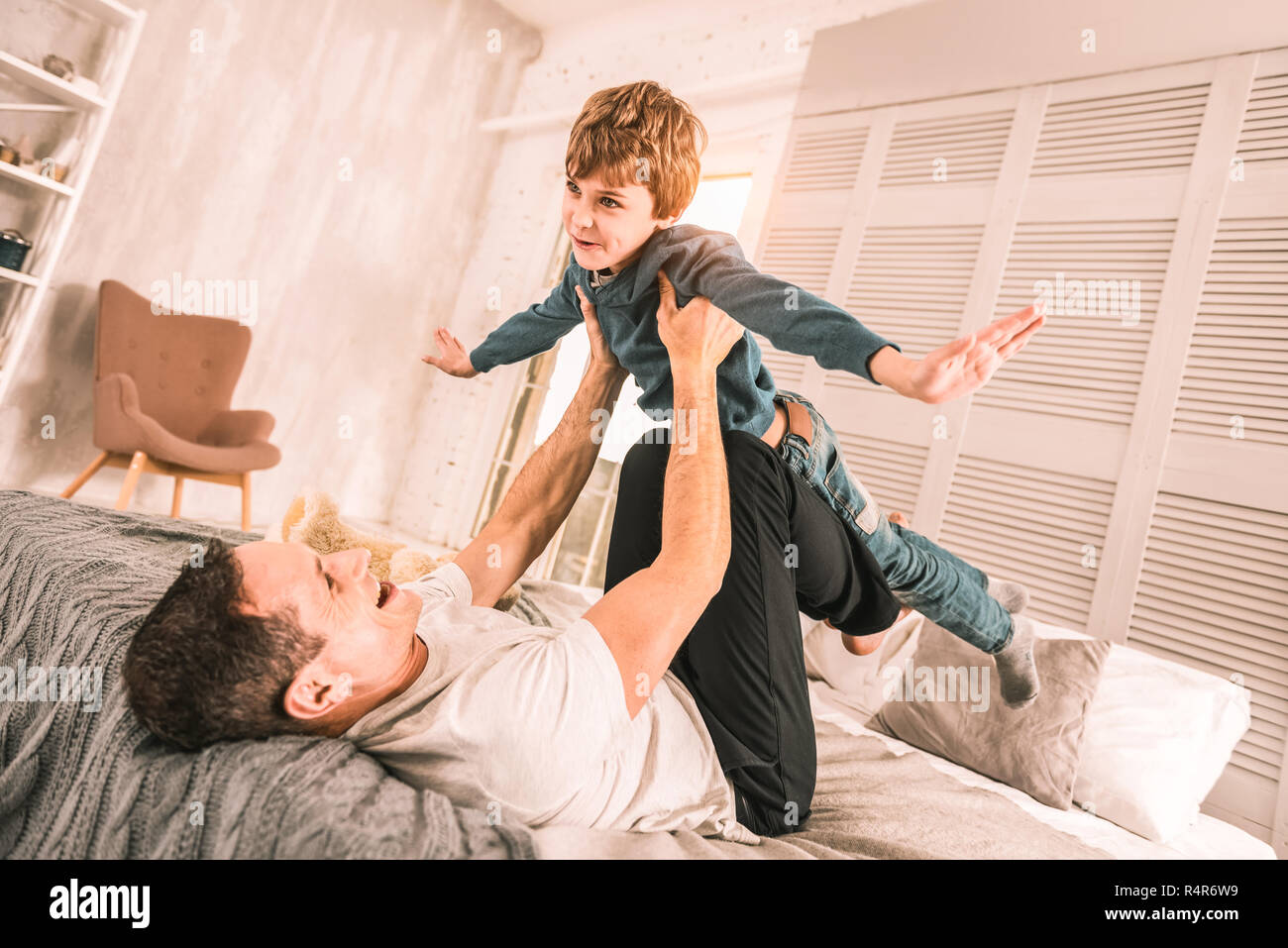 Liebevolle Eltern vorsichtig mit seinem Kind über ihm. Stockfoto