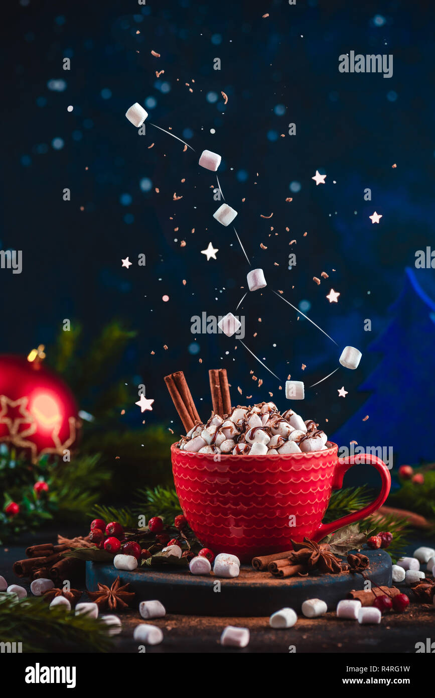 Marshmallow Ursa Major Konstellation mit Schokolade Krümel über eine rote Tasse Weihnachten heiße Schokolade. Winter Drink auf einem dunklen Hintergrund mit Kopie spac Stockfoto