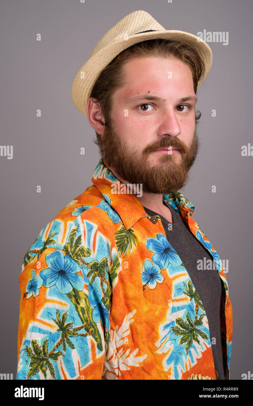 Junge Bartgeier touristische Mann bereit für Ferienhäuser gegen Grau backgr Stockfoto