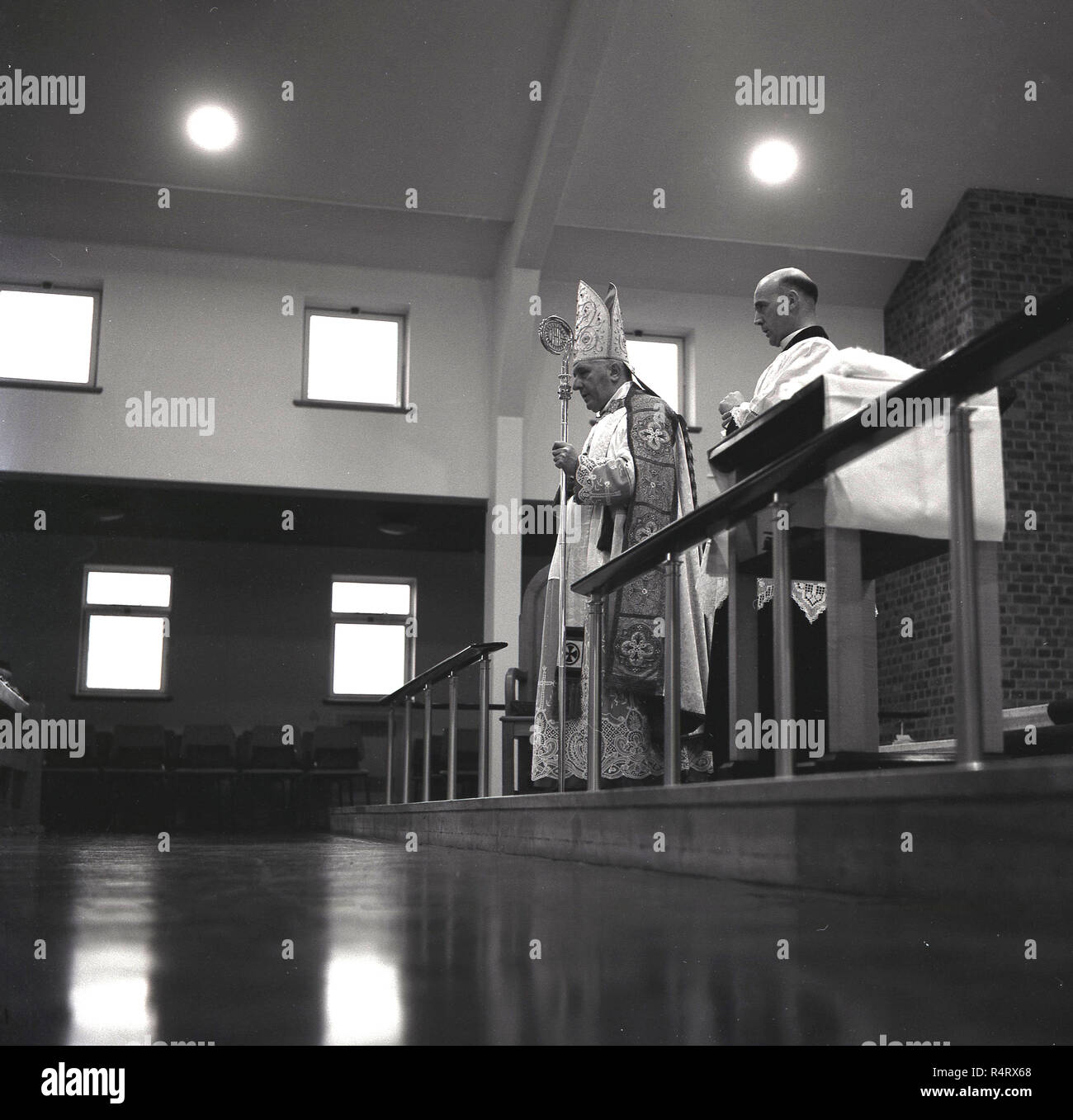 1965, historische, römisch-katholischer Priester, in einem modernen erbaute Kirche stand auf der Kanzel. Stockfoto