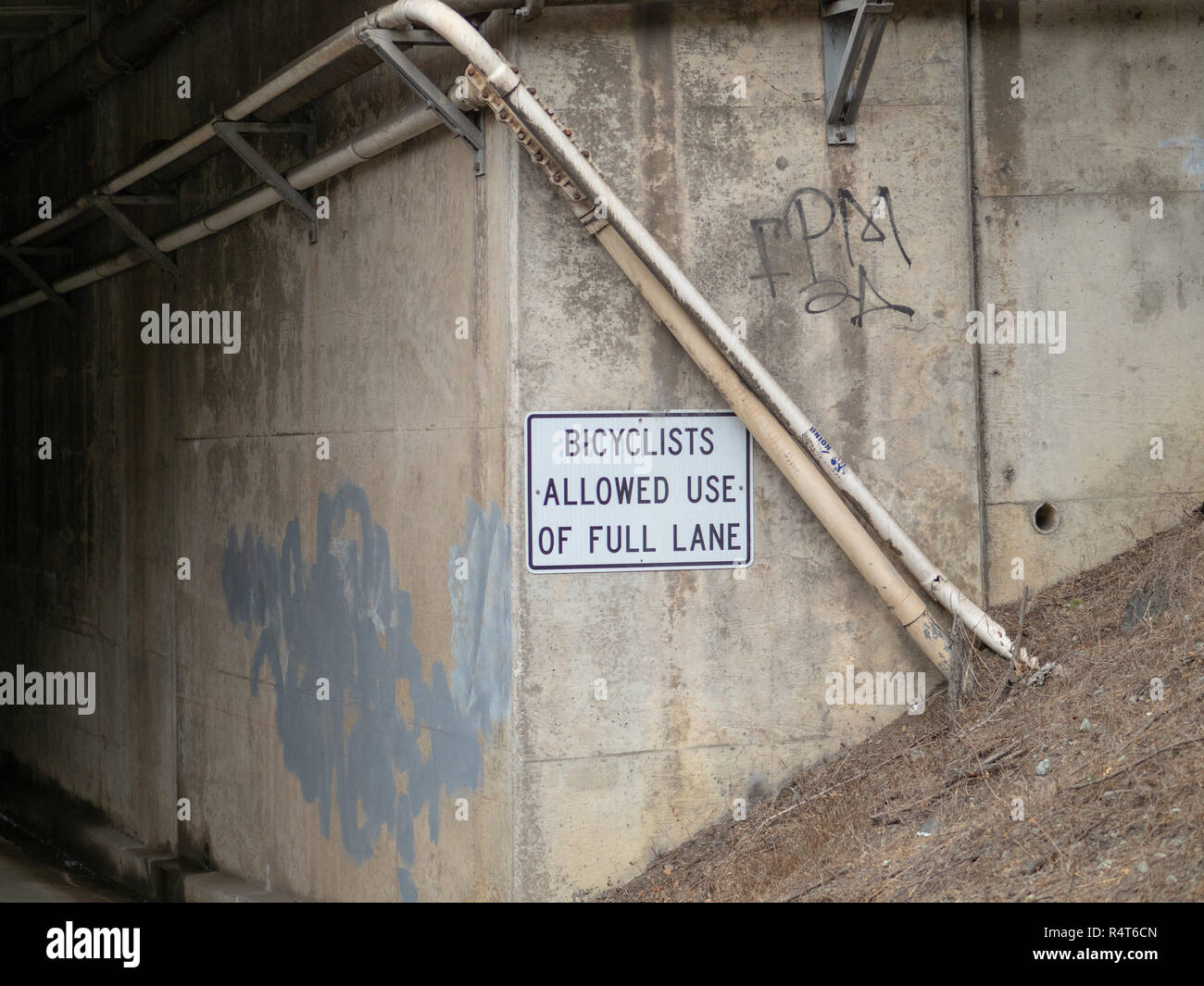 Radfahrer erlaubt die volle Lane Zeichen auf der Straße Tunnel führt zu dunklen Bereich ausgehängt Stockfoto