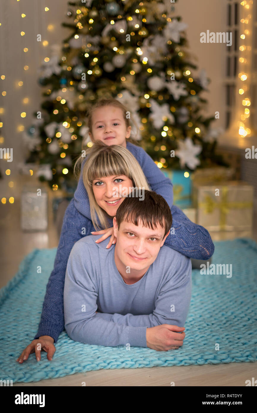 Junge Familie auf einem Blue Plaid in der Nähe von Weihnachten Baum Stockfoto