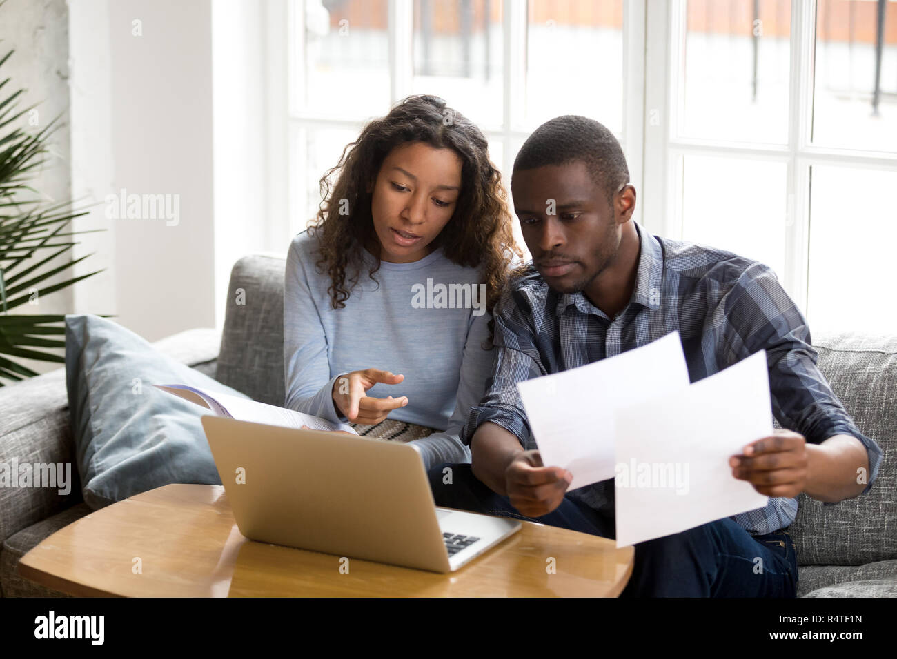 Schwere Afrikanische amerikanische Paar diskutieren Dokumente auf Papier Stockfoto